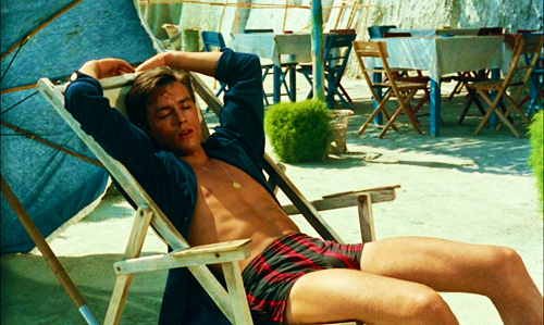 Alain Delon in Striped Swimwear Rests on the Beach in Half-Shadow, Half-Sunlight (Purple Noon, 1960)